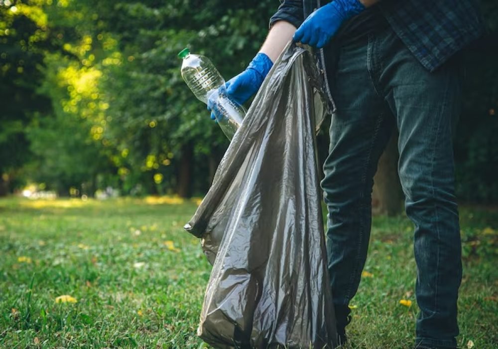 imgi_39_man-cleans-up-forest-throws-bottle-into-trash-bag-closeup_169016-23002